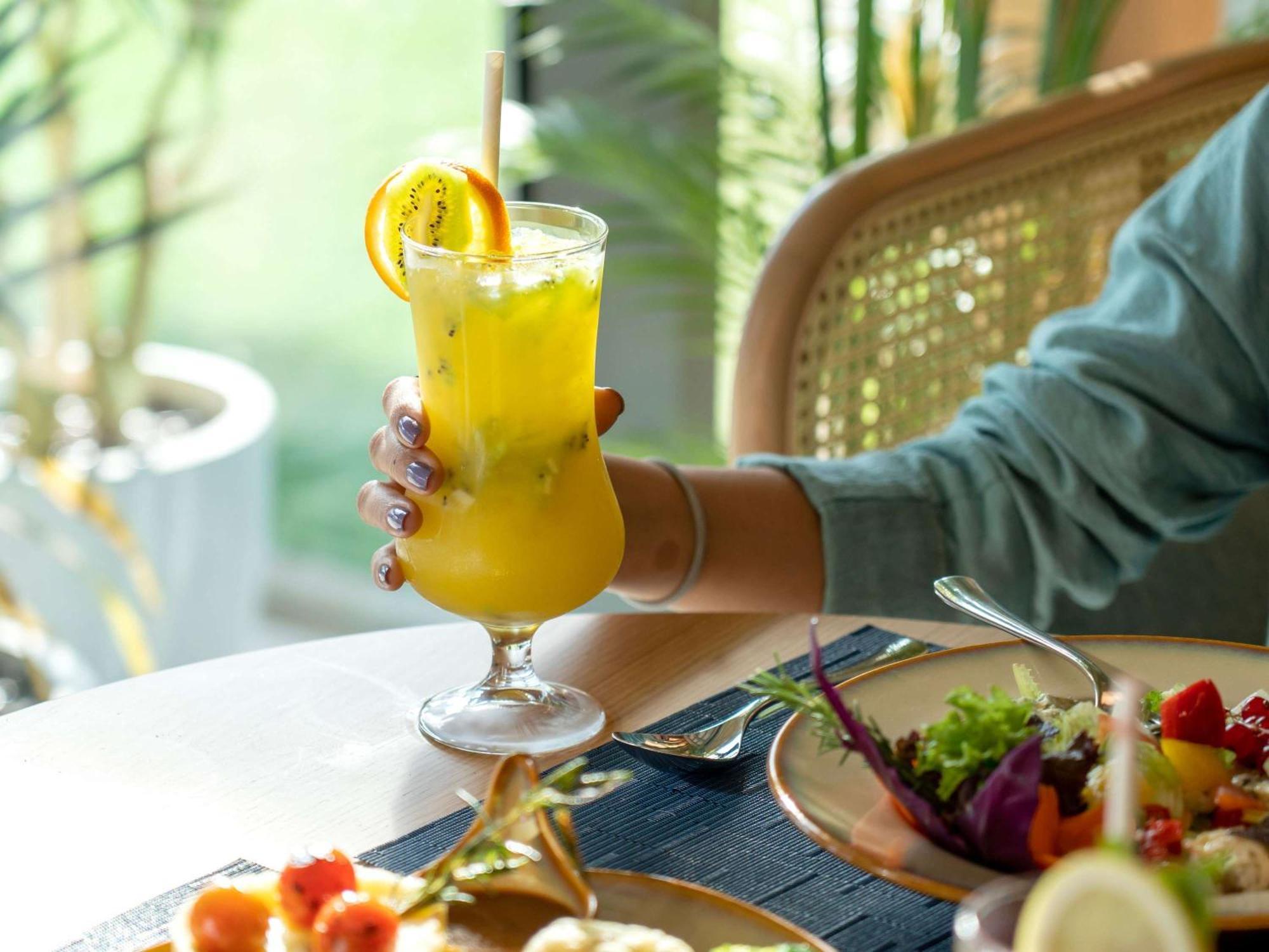 Swissotel Living Jidda Eksteriør bilde A woman holding a glass of juice